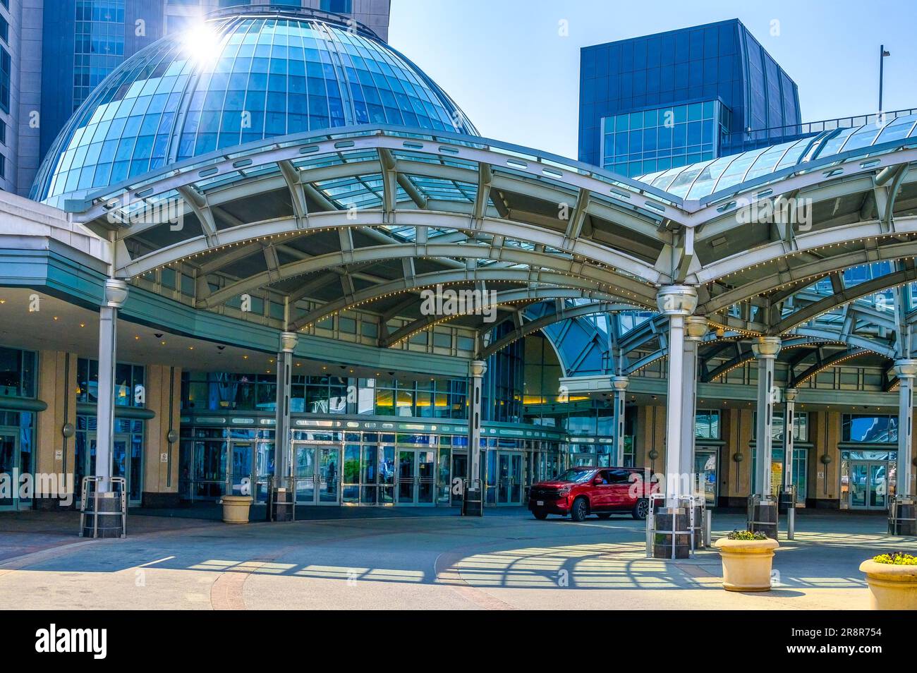 Fallsview Casino Resort, Niagara Falls City, Canada. Sunlight reflects in the exterior glass of the dome. Architectural arches at the building entrance Stock Photo