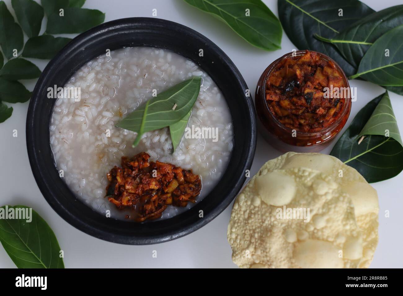 https://c8.alamy.com/comp/2R8RB85/kanji-and-kadumanga-rice-gruel-prepared-with-matta-rice-served-in-earthen-pot-in-a-traditional-way-with-spoon-made-of-jackpot-tree-leaf-shot-with-r-2R8RB85.jpg