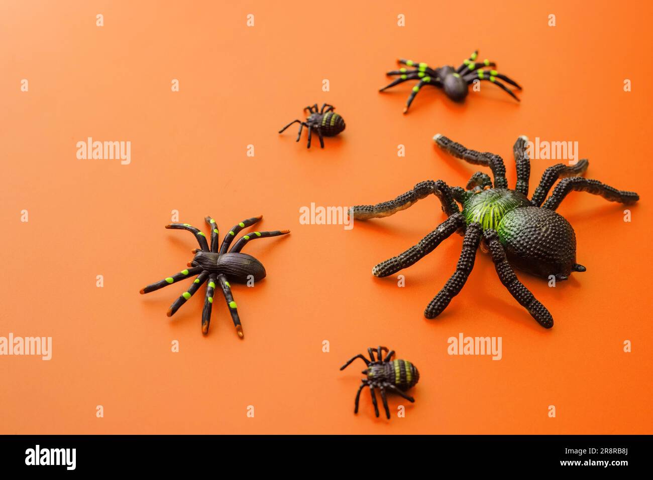 Group of black toy spiders on a orange background for halloween Stock ...
