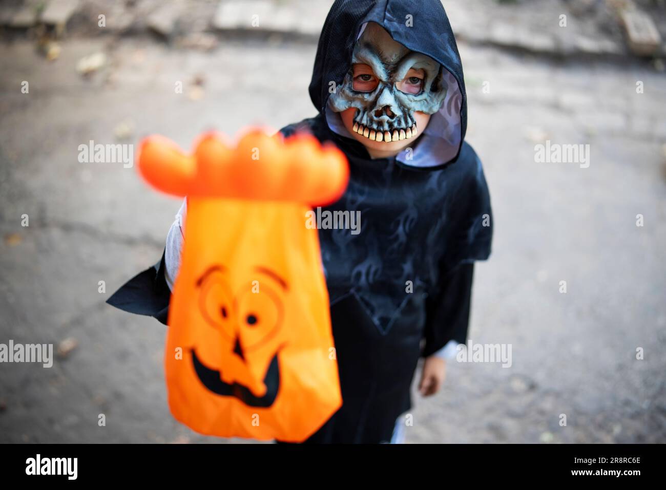 Little boy in halloween costume and mask holding special candy bag in his hand. Stock Photo
