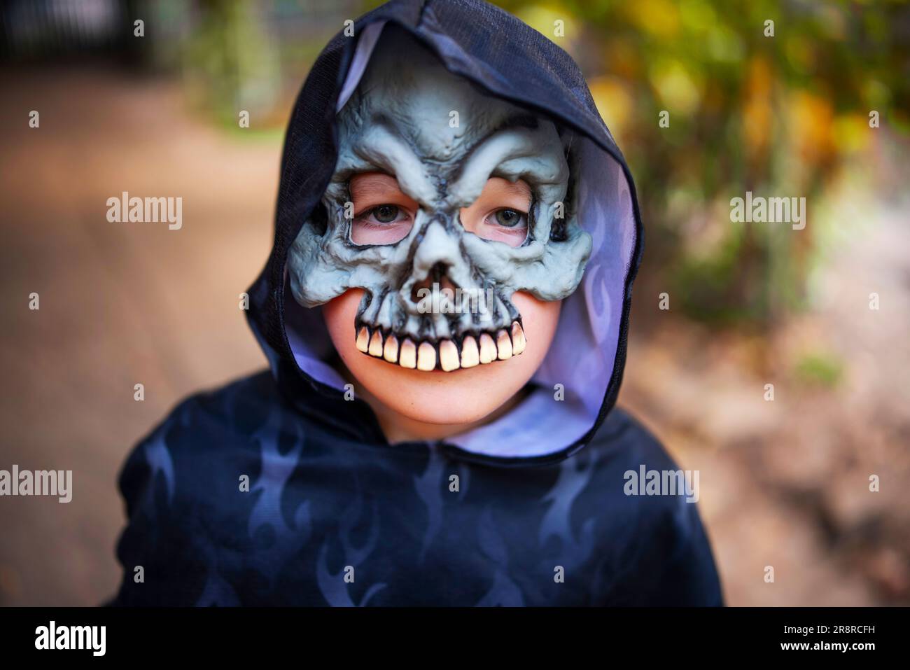 Portrait of a little boy in a halloween costume and mask outdoor. Trick or treat Stock Photo
