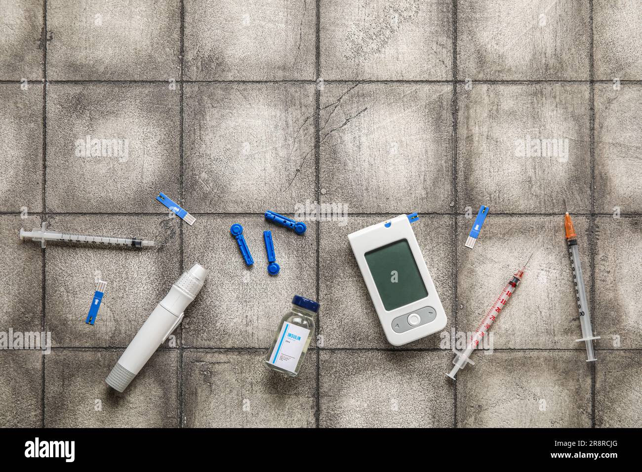 with insulin, lancet pen and syringes on dark tile