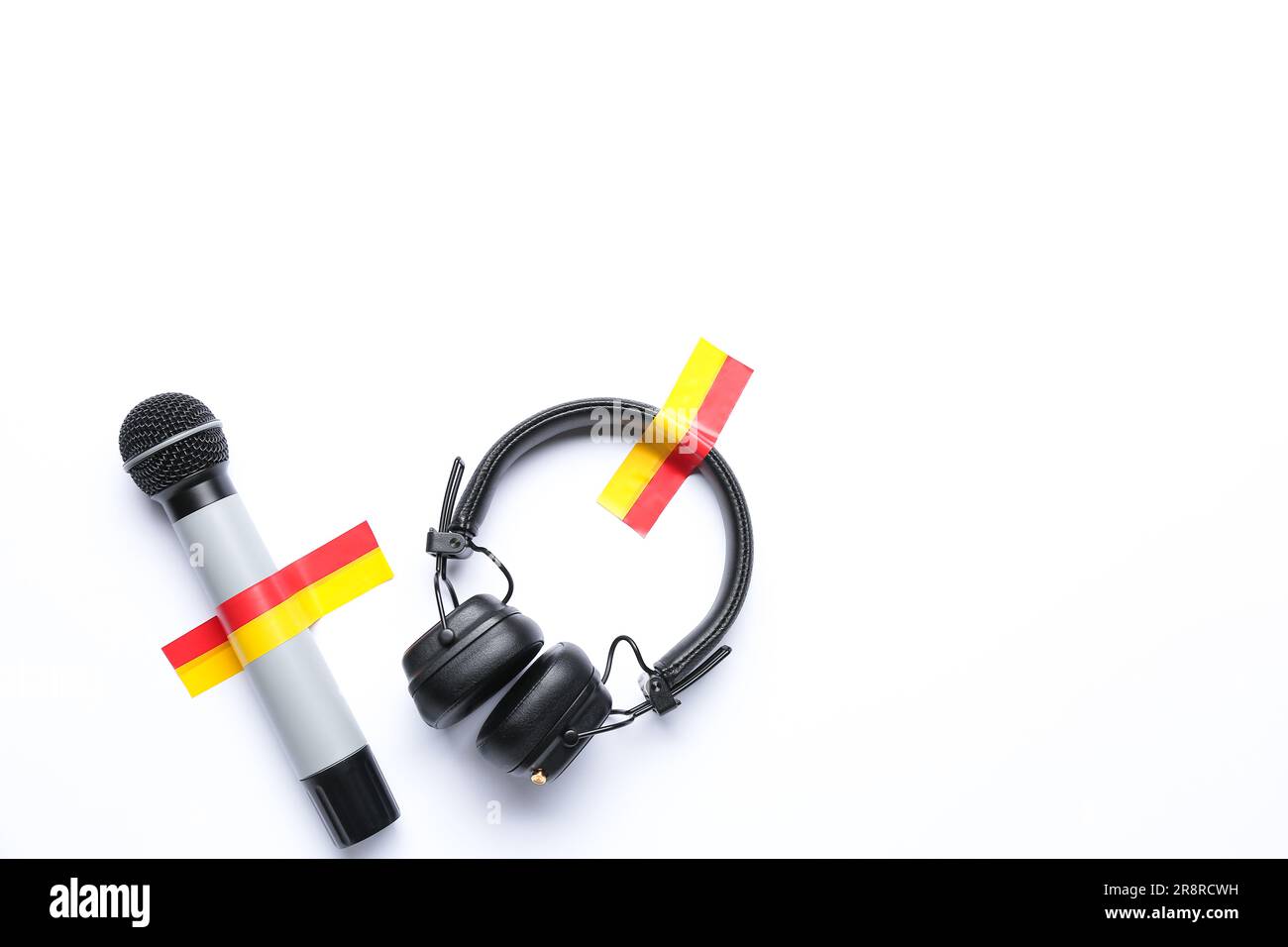 Microphone with headphones and adhesive tapes on white background Stock