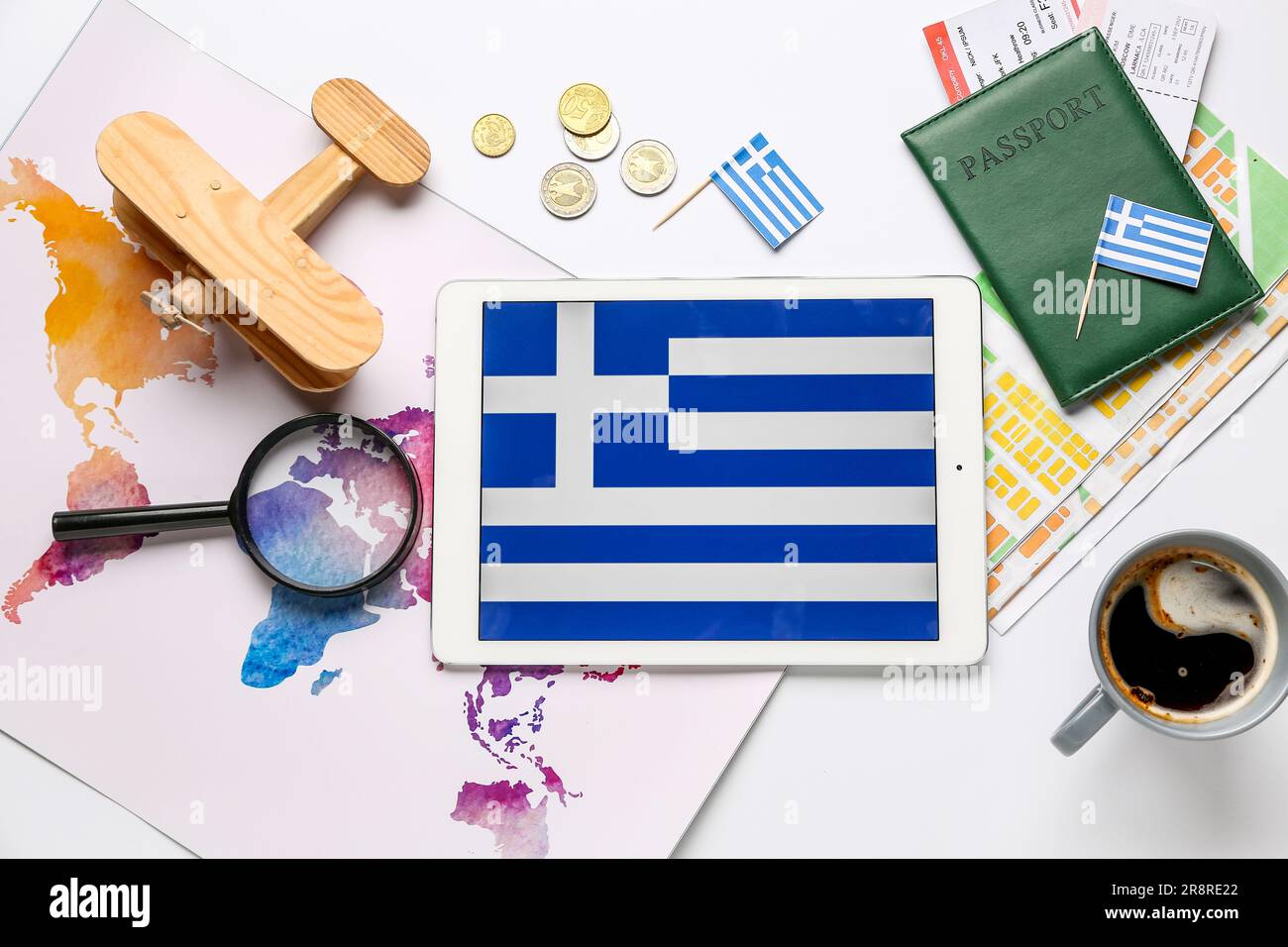 Tablet computer with flag of Greece, world map, passport and wooden ...