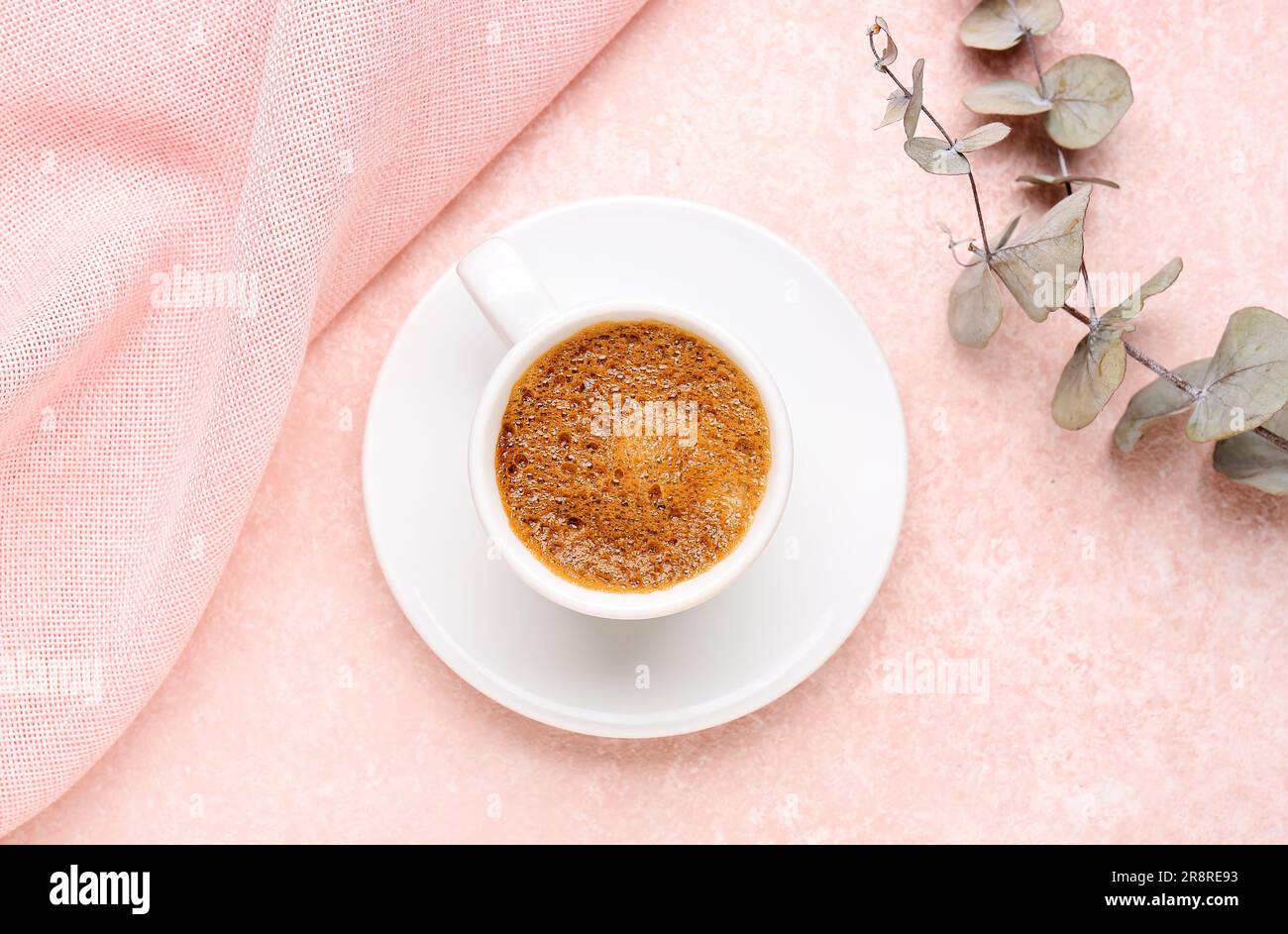 Cup of hot espresso and eucalyptus on pink background Stock Photo
