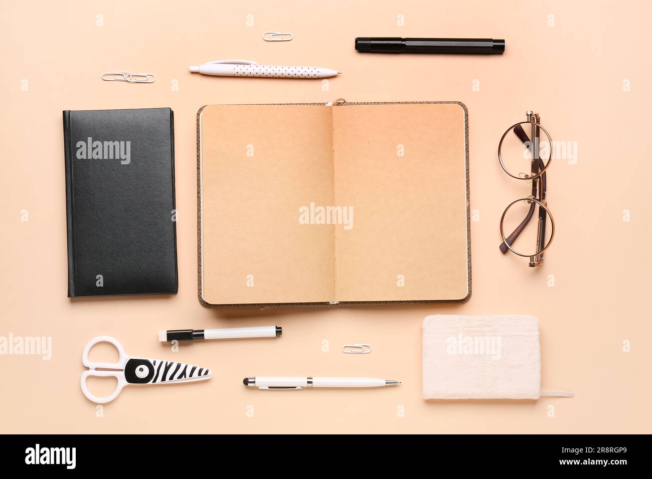 Notebooks with different stationery on pale orange background Stock Photo