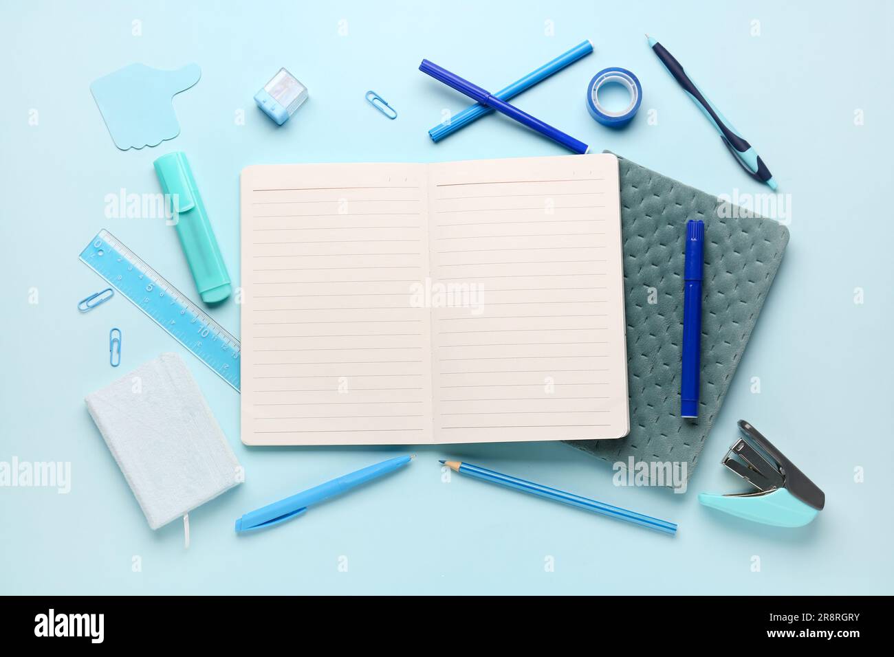 Notebooks with different stationery on blue background Stock Photo