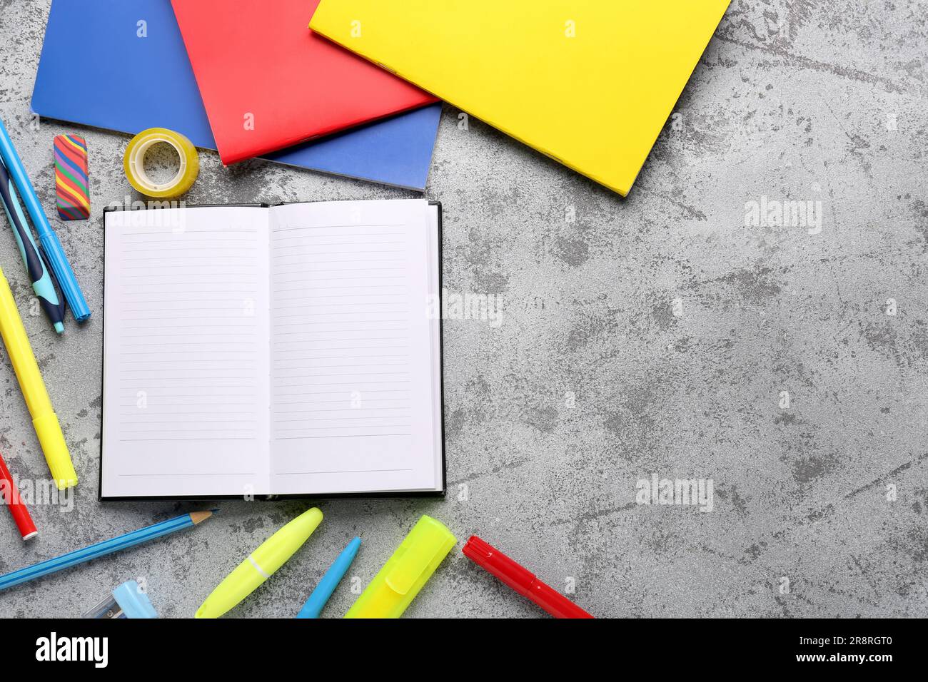 Notebooks with different stationery on grunge grey background Stock Photo