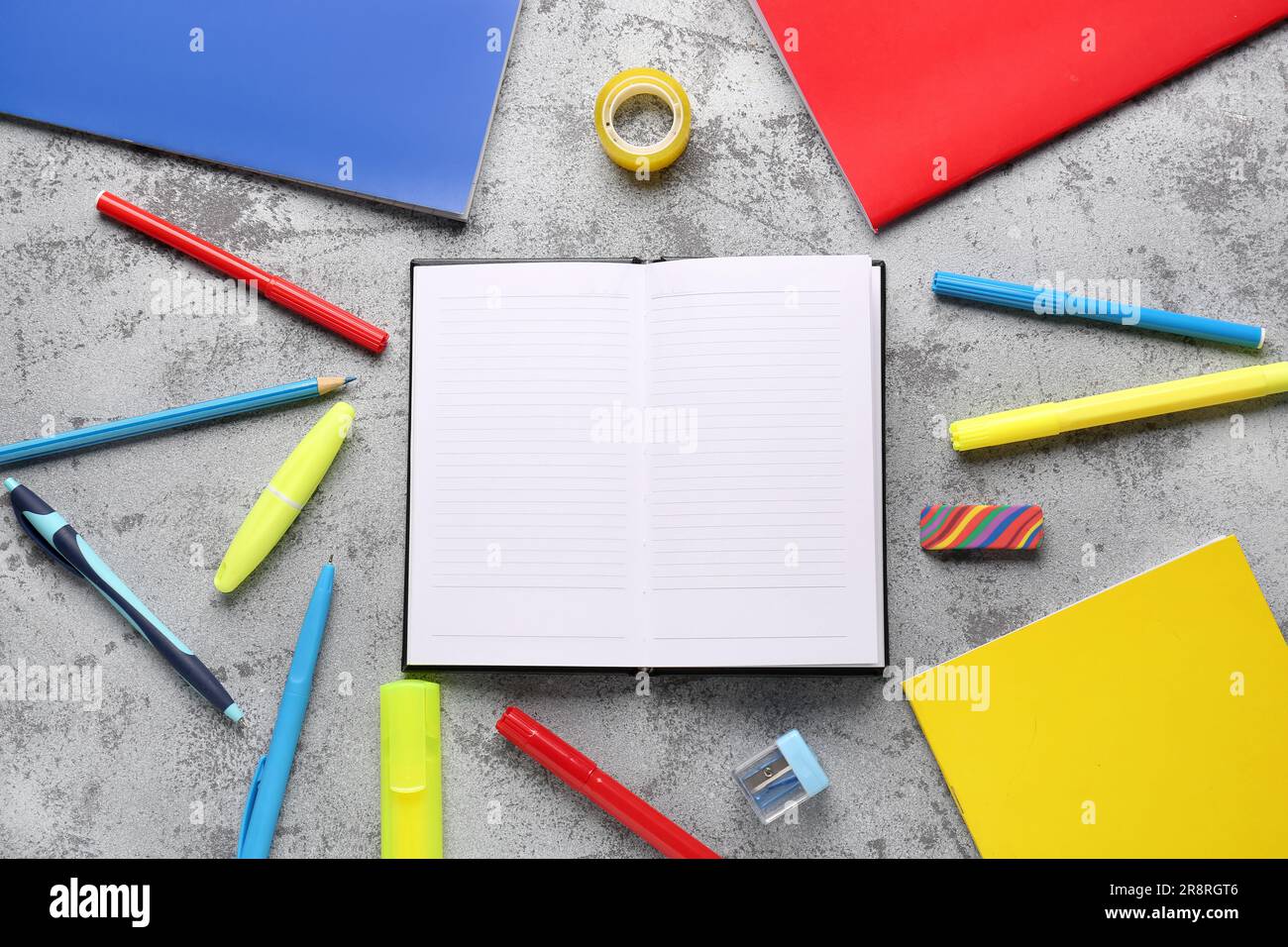 Notebooks with different stationery on grunge grey background Stock Photo