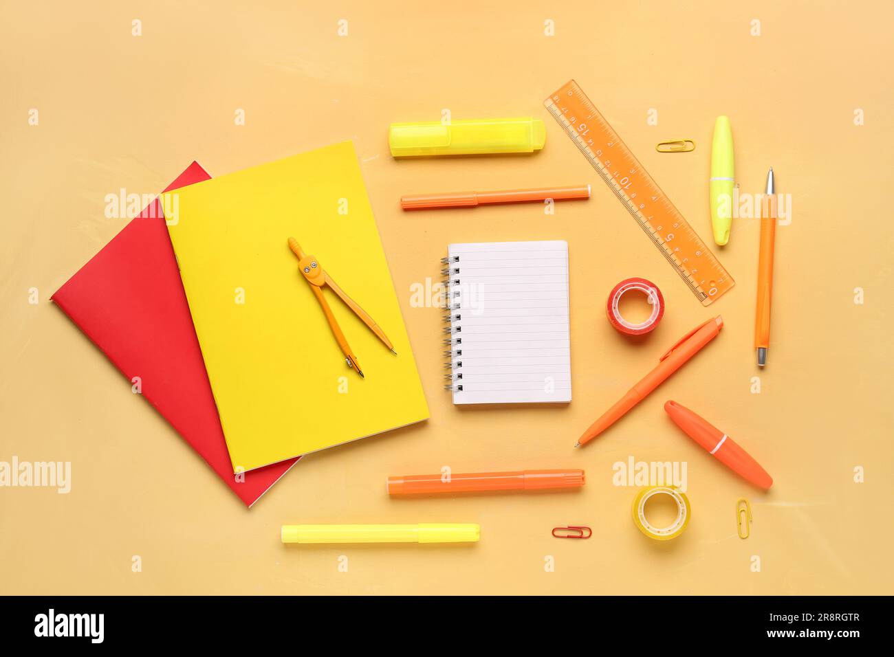Notebooks with different school stationery on orange background Stock Photo