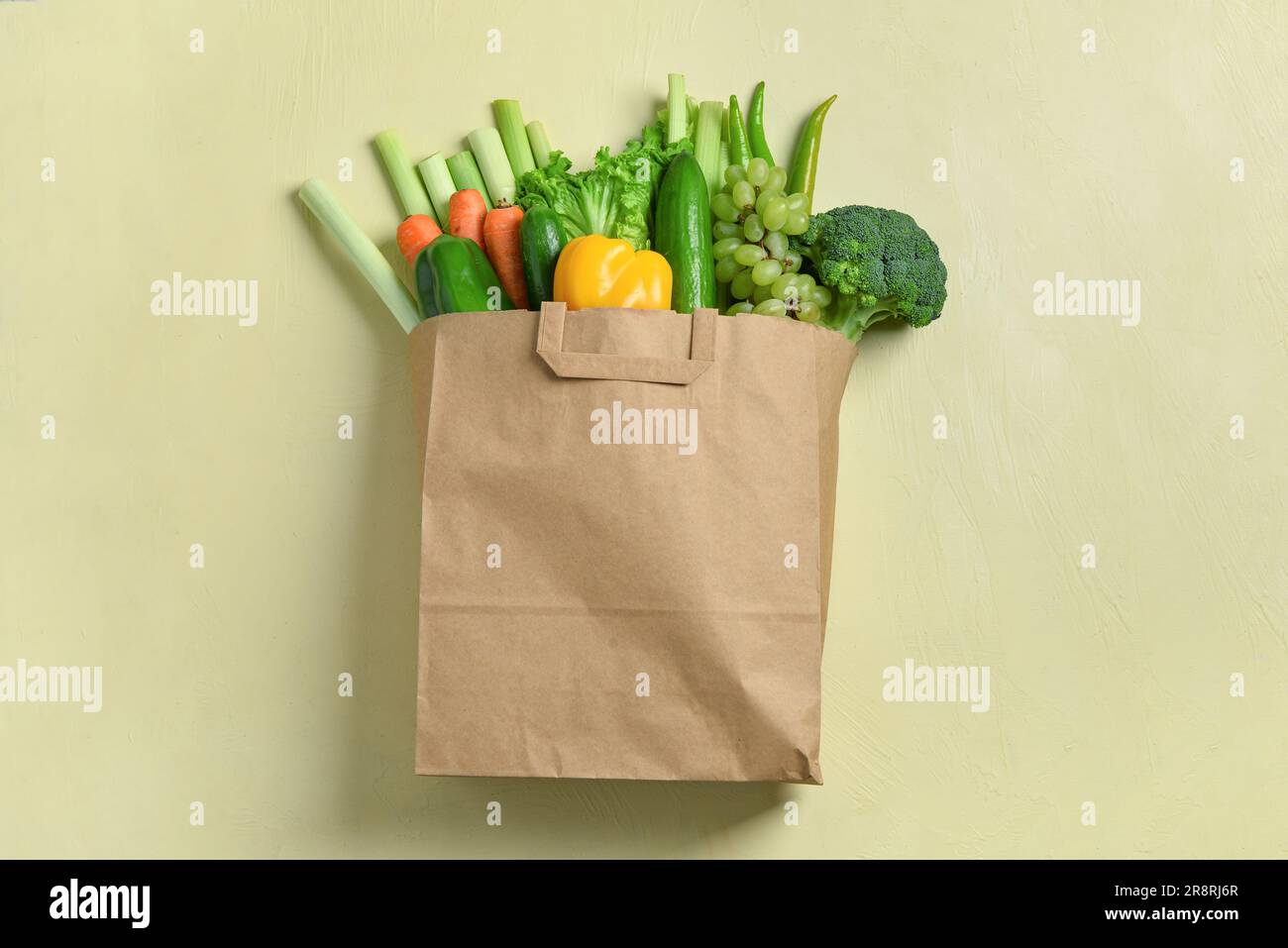 Paper bag with fresh vegetables and fruits on beige background Stock ...