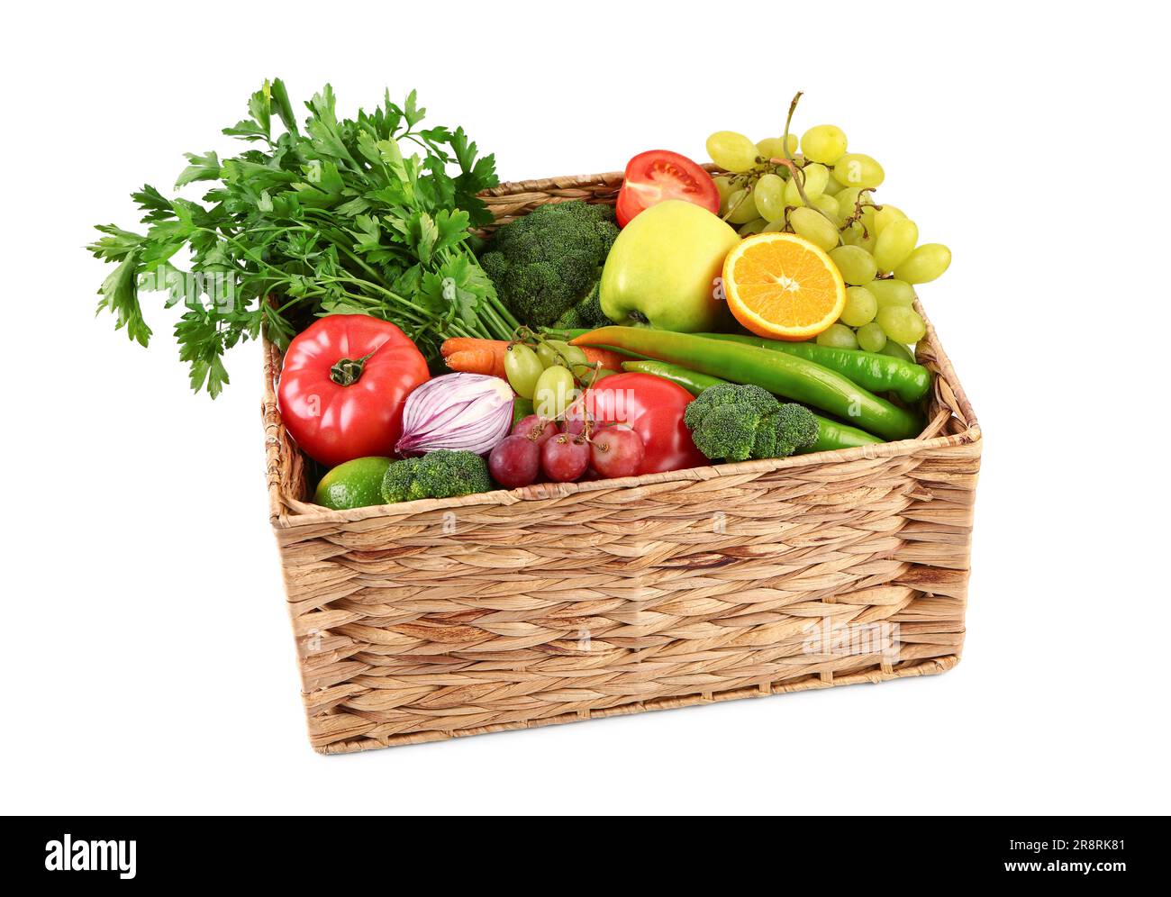 Wicker box with different fresh fruits and vegetables on white ...