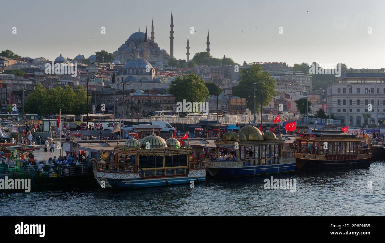 Balik Ekmek (fish sandwich) boats at Eminonu beside the Golden Horn river in Istanbul, Turkey. Suleymaniye Mosque on the hill behind Stock Photo