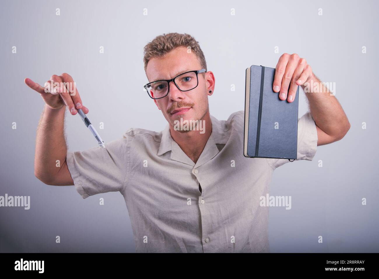 A writer is holding a pen and an agenda, confident expression, studio photo Stock Photo