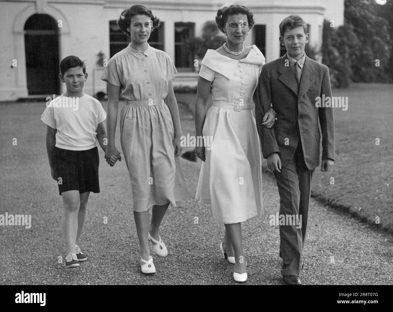 Duchess of Kent And Her Children -- A charming family picture of the Duchess of Kent and her children as they walk in the grounds of their home, 'Coppins', Iver, Buckinghamshire. Left to right:- Prince Michael, Princess Alexandra, The Duchess of Kent and the Duke of Kent. August 14, 1950. (Photo by Paul Popper Ltd.). Stock Photo