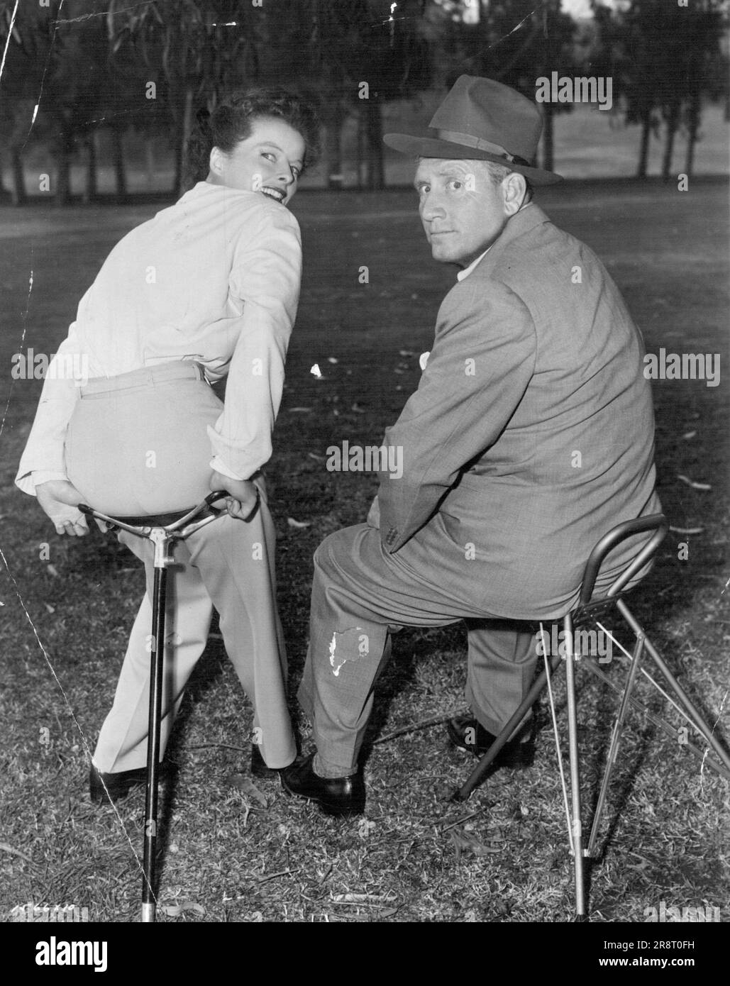 Pause that refreshes... Spencer Tracy and Katharine Hepburn take time out between scenes of their latest M-G-M comedy, 'Pat and Mike'. Directed by George Cukor. Produced by Lawrence Weingarten. Written by Ruth Gordon and Garson Kanin. September 06, 1952. Stock Photo