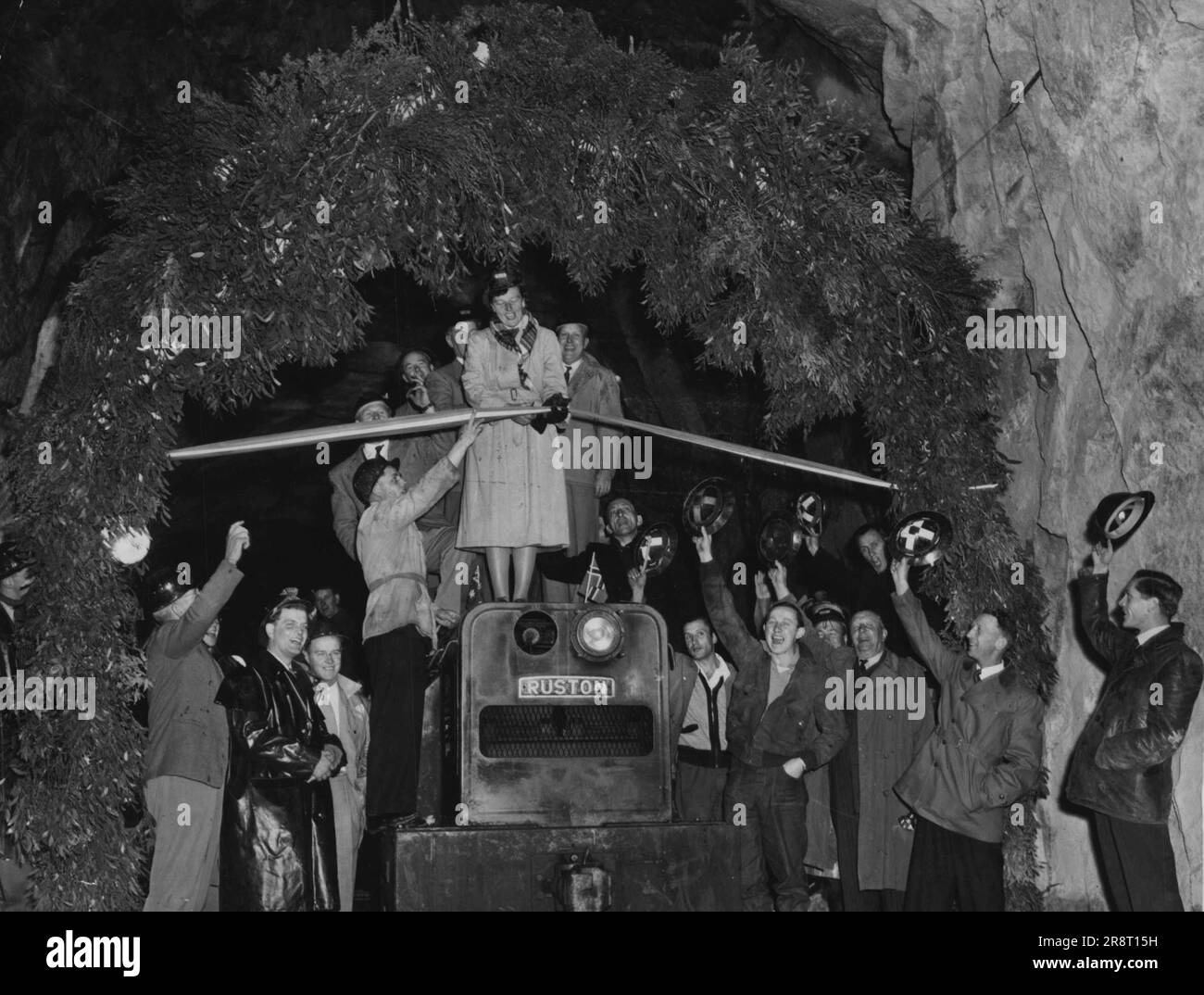 Mrs. W. Hudson cutting the ribbon which officially opened the Guthega to Munyang tunnel in the Snowy Mountains scheme. Mrs. Hudson is the wife of the Commissioner of the Snowy Mountains Hydro-Electric Authority. Ceremony took place in tunnel on Friday night. May 11, 1954. Stock Photo