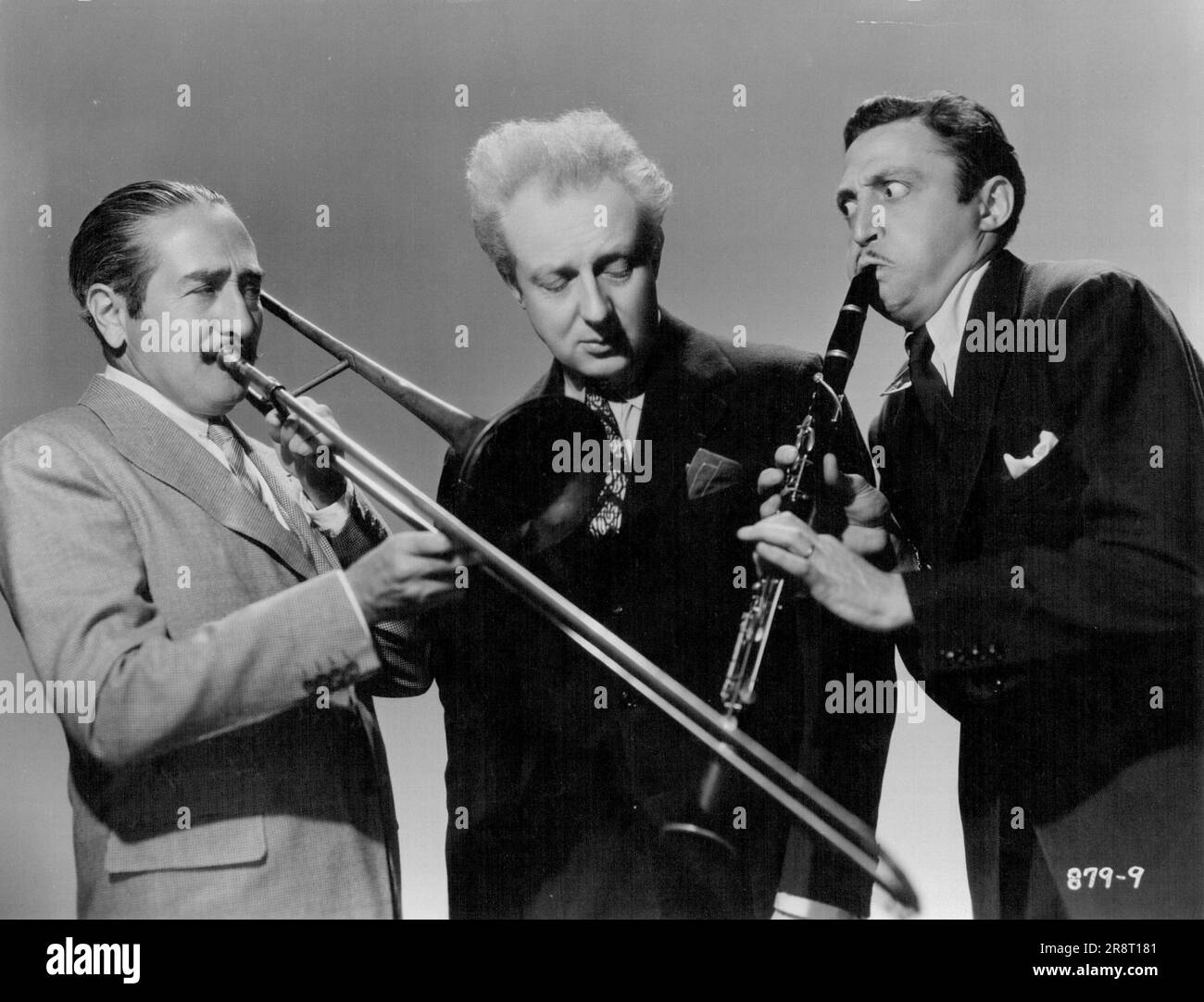 Leopold Stokowski looks disdainful as Mischa Auer and Adolphe Menjou display their musical ability in Universal '100 Men' a Girl. January 3, 1938. Stock Photo