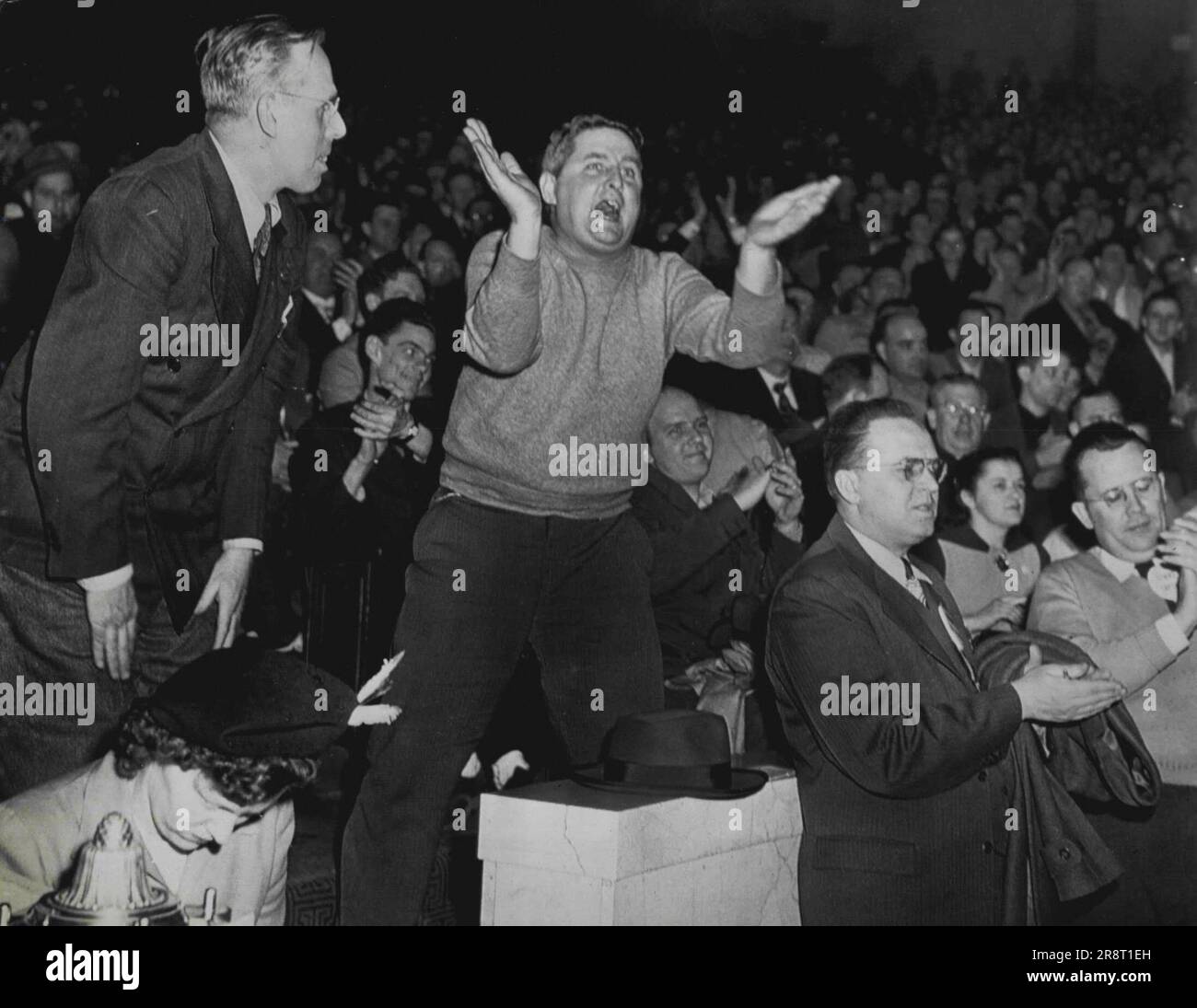 Striker Shouts Against Settlement - A worker of the Philadelphia Transportation company shouts against settling the transit strike here early today during a mass meeting of strikers after negotiators had reached agreement in the ten-day strike. Other strikers applaud or shout during the stormy session. February 20, 1949. (Photo by AP Wirephoto). Stock Photo