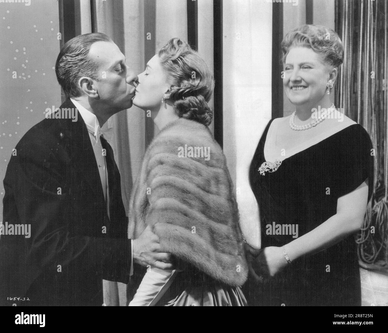 Happy Ending. . . A Kiss for Romberg from his beloved wife. Jose Ferrer is Romberg with Doe Avedon as his wife and Helen Traubel in the role of his devoted friend for M-G-M's all-star musical 'Deep In My Heart', based on the life and music or Romberg. Color, Wide-screen musical romance starring Jose Ferrer, Merle ***** Helen Traubel, Walter Pidgeon, and Doe Avedon. The Cast also includes a galaxy of Glamorous guest stars including Rosemary Clooney, Fred And Gene Kelly, Ann Miller Cyd Charisse, James Mitchell, Tony Martin, Jane Powell, Vic Damone, Howard Keel and Joan Weldon. February 12, 1955. Stock Photo