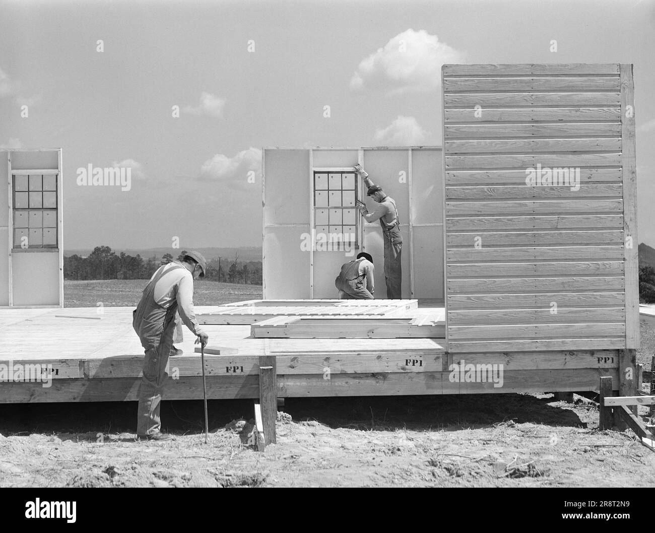 Construction workers building prefabricated houses for tenant farmers being relocated due to construction of Camp Croft, a U.S. Army Infantry Replacement Training Center, near Pacolet, South Carolina, USA, Jack Delano, U.S. Farm Security Administration, March 1941 Stock Photo