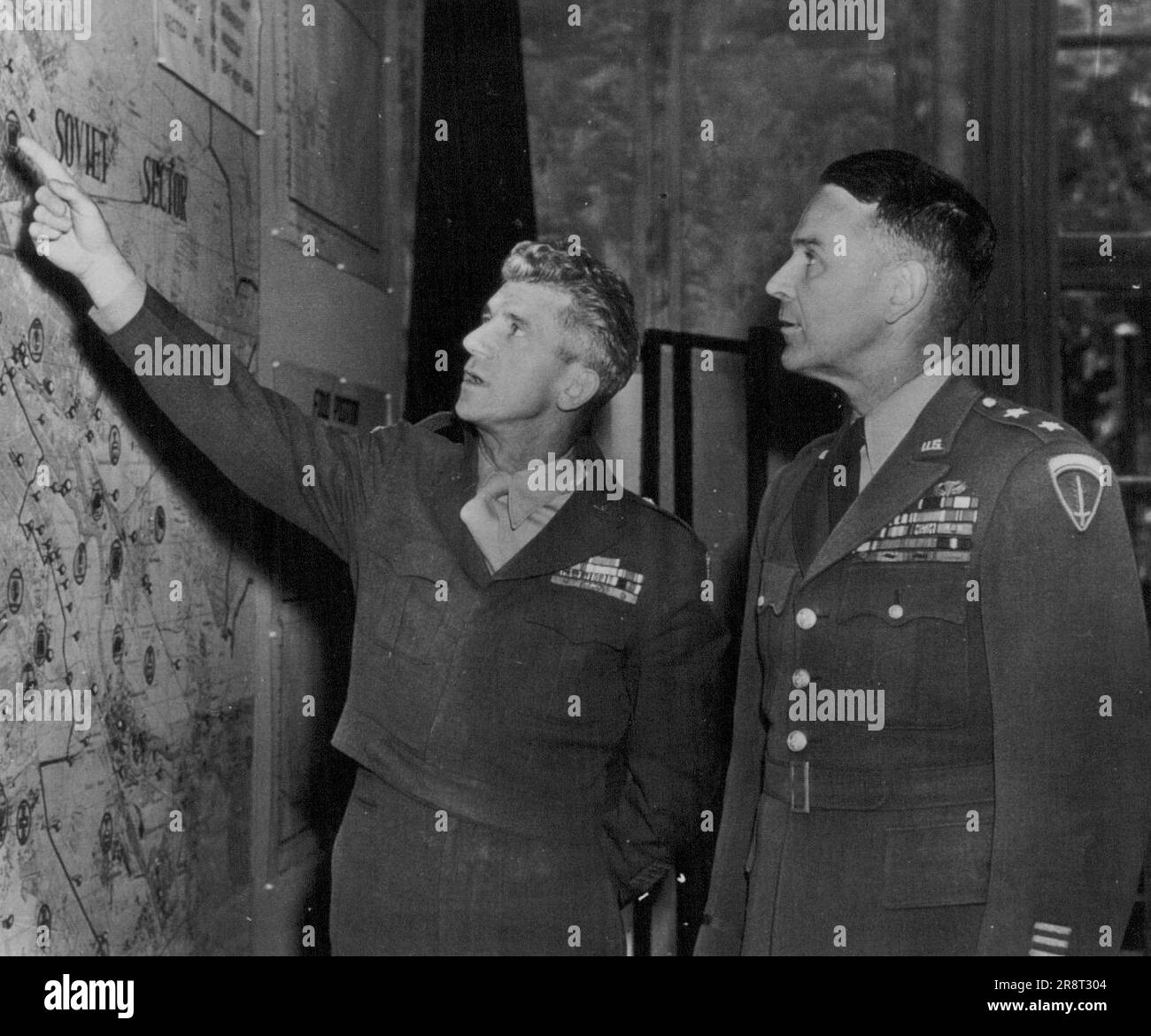 Maj. Gen. Maxwell D. Taylor (right), named officially yesterday to command the American Military Government and the Army forces in Berlin, and Brig. Gen. Frank Howley, look at a map of Berlin in headquarters there on Tuesday. General Taylor, wartime paratroop leader, succeeds Howley as commandant and Col. James T. Duke as commander of the Berlin military a post. The double authority was given him 'in order to unify the United States position in Berlin.' August 7, 1949. (Photo by AP Wirephoto). Stock Photo