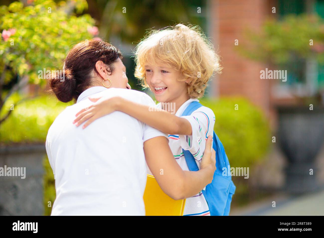 Mother bringing child to school. Parents pick up little boy after class