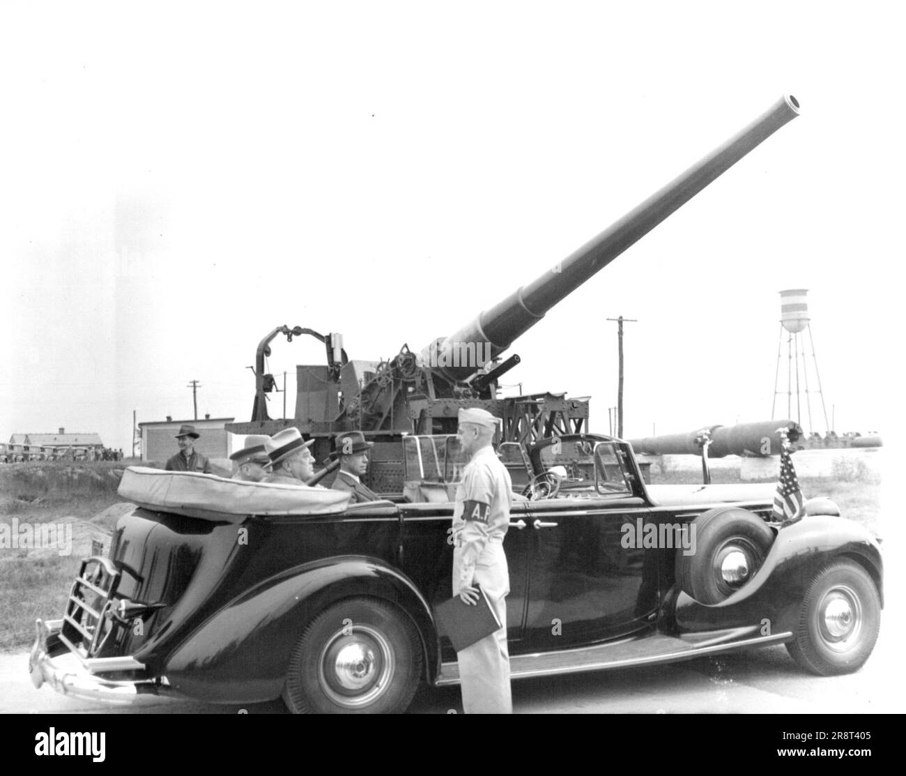 FDR Sees Anti-Craft Guns -- President Rossevelt got a close-up view of guns the army would use to protect the nation against aerial bombardment when he visited the army's proving ground at Aberdeen, Md., Sept. 30 with the President as he drives past a battery of mobile anti-aircraft guns is Major General C.M. Wesson, army Chief of ordnance. September 30, 1940. (Photo by Associated Press Photo). Stock Photo