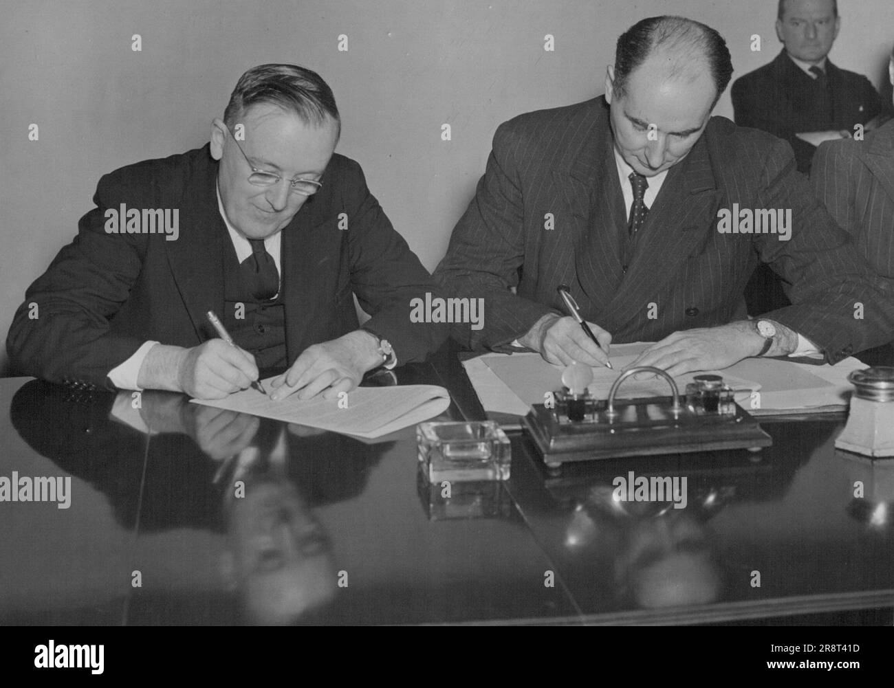 Australian Egg Contract Signed -- Mr. Strachey, and Mr. J. Beasley, High Commissioner for Australia, signing the contract. Mr. John Strachey, Minister of Food, and Mr. J. Beasley, High Commissioner for Australia, signed the Australian egg contract in London today, (Thur). Under this new contract, which covers a period of five years from 1st. July 1948, the Ministry of Food will buy the total exportable surplus of Australian eggs and egg products. It provides for increased prodcution in Australia with an objective of an export target of 105 million dozen egg products. March 25, 1948. (Phot… Stock Photo