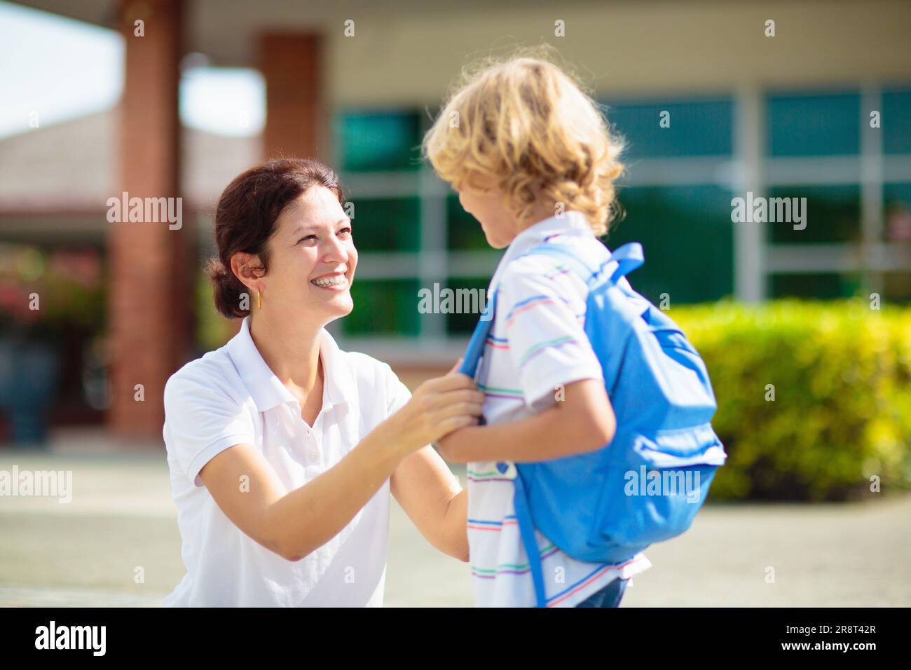Mother bringing child to school. Parents pick up little boy after class