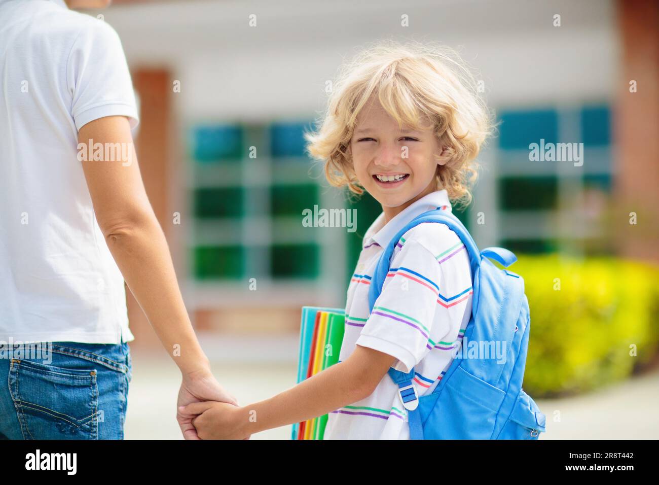 Mother bringing child to school. Parents pick up little boy after class