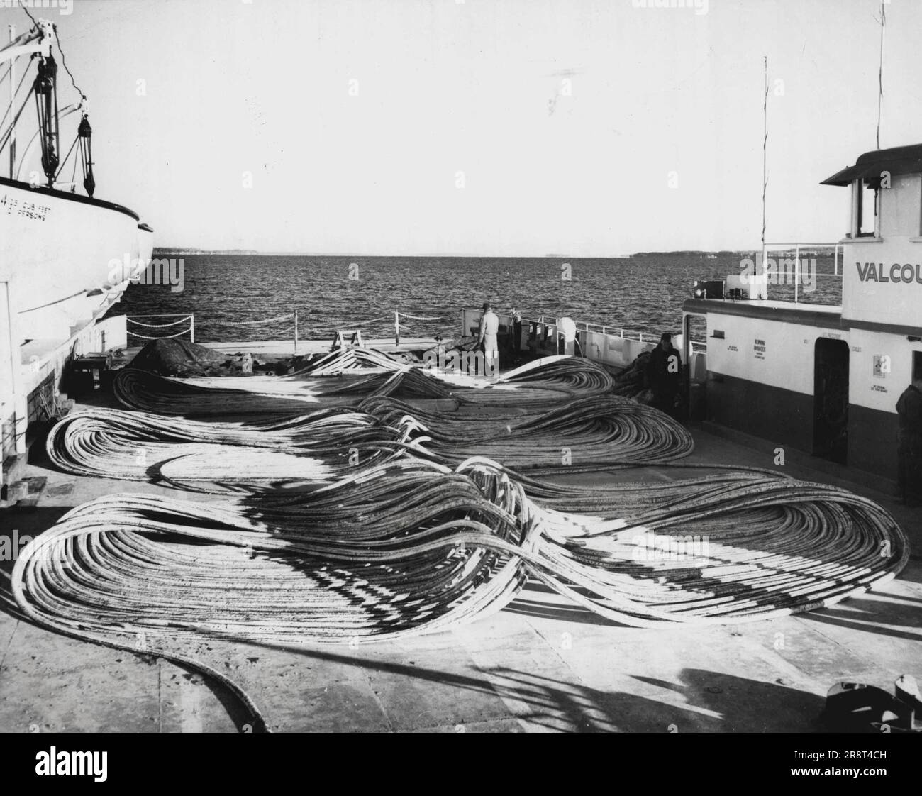 "Here's The Sauce? Spaghetti-like telephone cable is laid out neatly on the deck of the Ferry Valcour, ready for laying across lake Champlain. The smooth coiling eased the job of laying the 10,000-foot cable between Grand Isle, VT., and Cumberland Head, N.Y. A week's work went into preparation for the operation, which took only four hours. The cable will double telephone circuits between Vermont and New York. February 12, 1955. (Photo by United Press Photo). Stock Photo