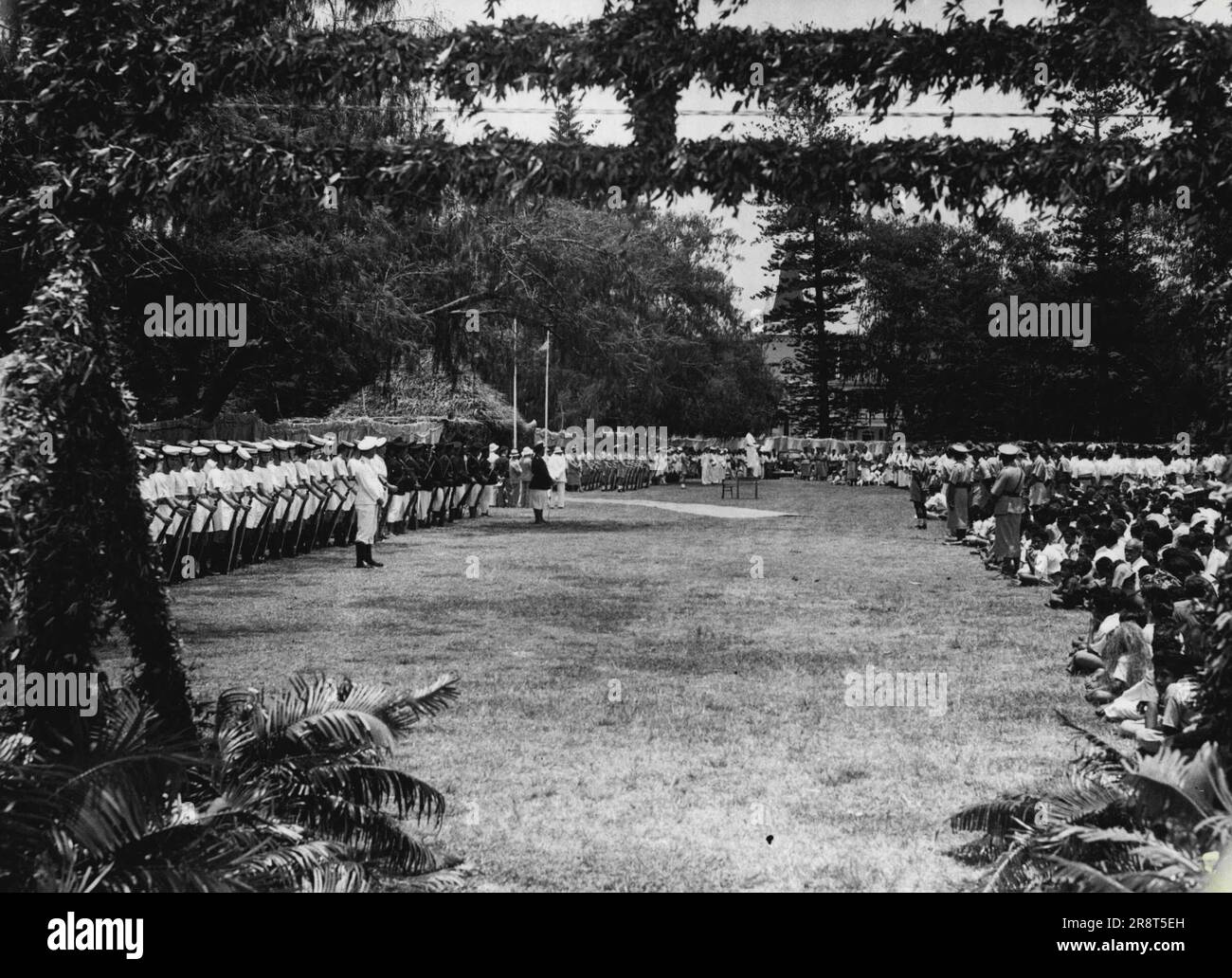 Tonga Celebrates Hundredth Anniversary of Foundation of Kingdom View of the Malae (public Park) with Royal Navy Guard of Honour before the presentation of the Insignia of Dame Grand Cross of the Order of the British Empire to Queen Salote Tubou. December 13, 1945. (Photo by Royal Naval Official Photograph). Stock Photo