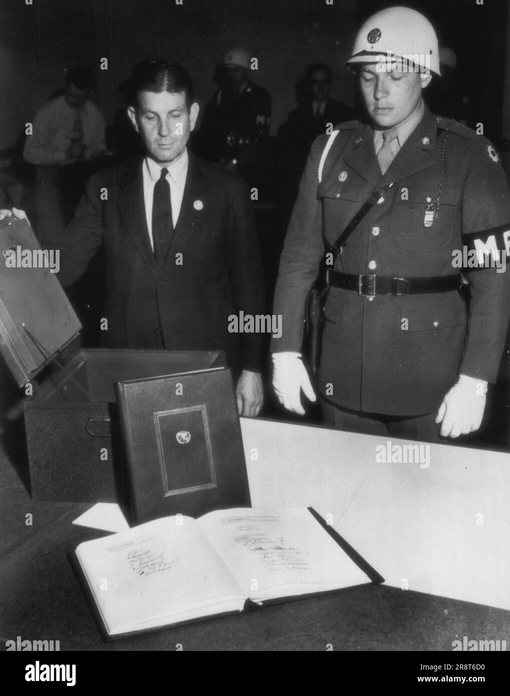 Charter Strong Box -- John A. Sutro, state department of official responsible for security of the United Nations charter (open in foreground) and Pvt. Edgar Price, military policeman, (right) Niagara Falls, N.Y., Display the strong box in which the charter and iterim agreement (propped against box) will be sent to Washington. June 28, 1945. (Photo by AP Wirephoto). Stock Photo