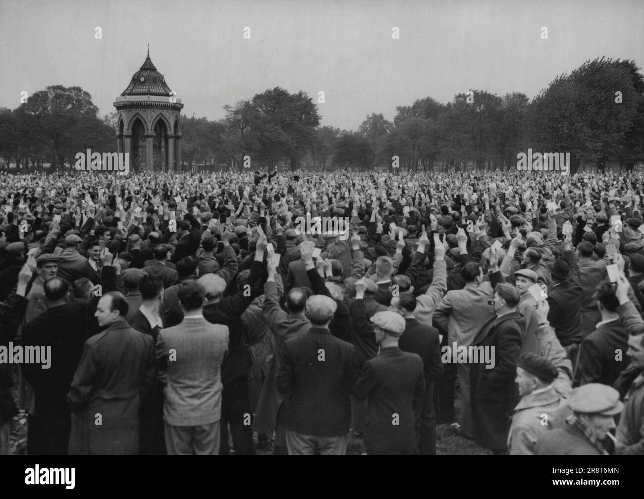The Strike Goes On -- London Dockers at a meeting in Victoria Park, East London, today October 12, raise their hands to vote for the continuation of their nine-day-old strike. there are 26,000 men out. October 12, 1954. (Photo by Associated Press Photo). Stock Photo