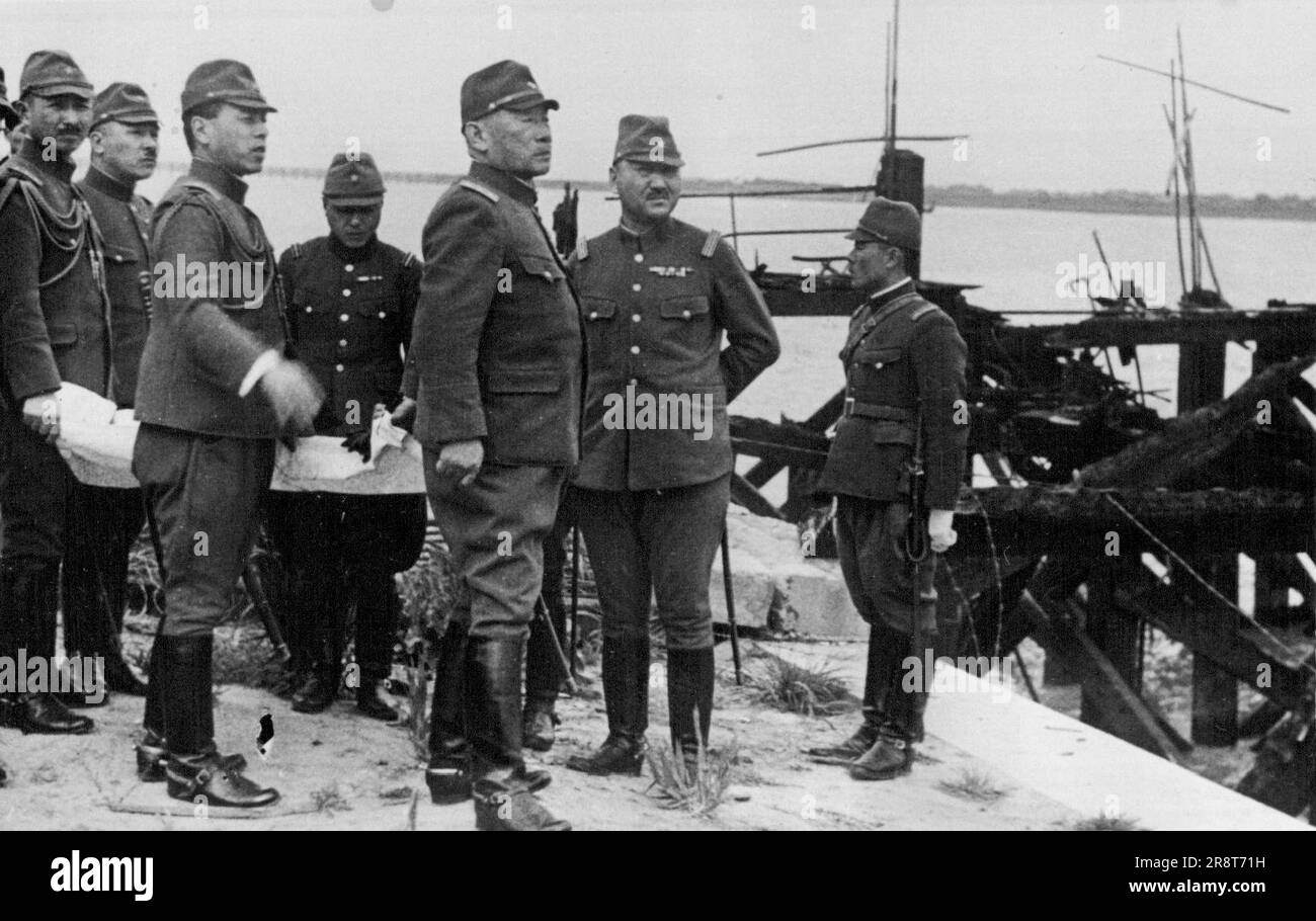 Japanese War Minister in Shanghai - General Gen Sugiyama, Japanese Minister of War, recently paid a flying visit to China inspecting conditions in North China and in Shanghai. General Sugiyama 13rd from right, is seen at Woosung, a few miles from Shanghai, looking over the ruined wharf where the first Japanese landing was effected. May 09, 1938. (Photo by Keystone). Stock Photo