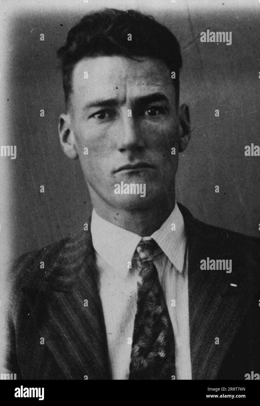 Arthur Ernest Halliday, native of New South Wales, 35. 5ft. 71/2in., slight build, brown hair, hazel eyes, fair complexion, scar inside left shin. Left little finger missing to second joint. Is wearing long trousers, grey or dark, a blue striped shirt, and an old felt hat. He is a notorious house-breaker, and in 1939 was sentenced to five years' gaol for a series of robberies. In January, 1940, he escaped from the Brisbane Prison at the same spot, and by the same means as he did yesterday, and was free for two weeks. He received mine months' gaol for having escaped, and sentences on steal… Stock Photo