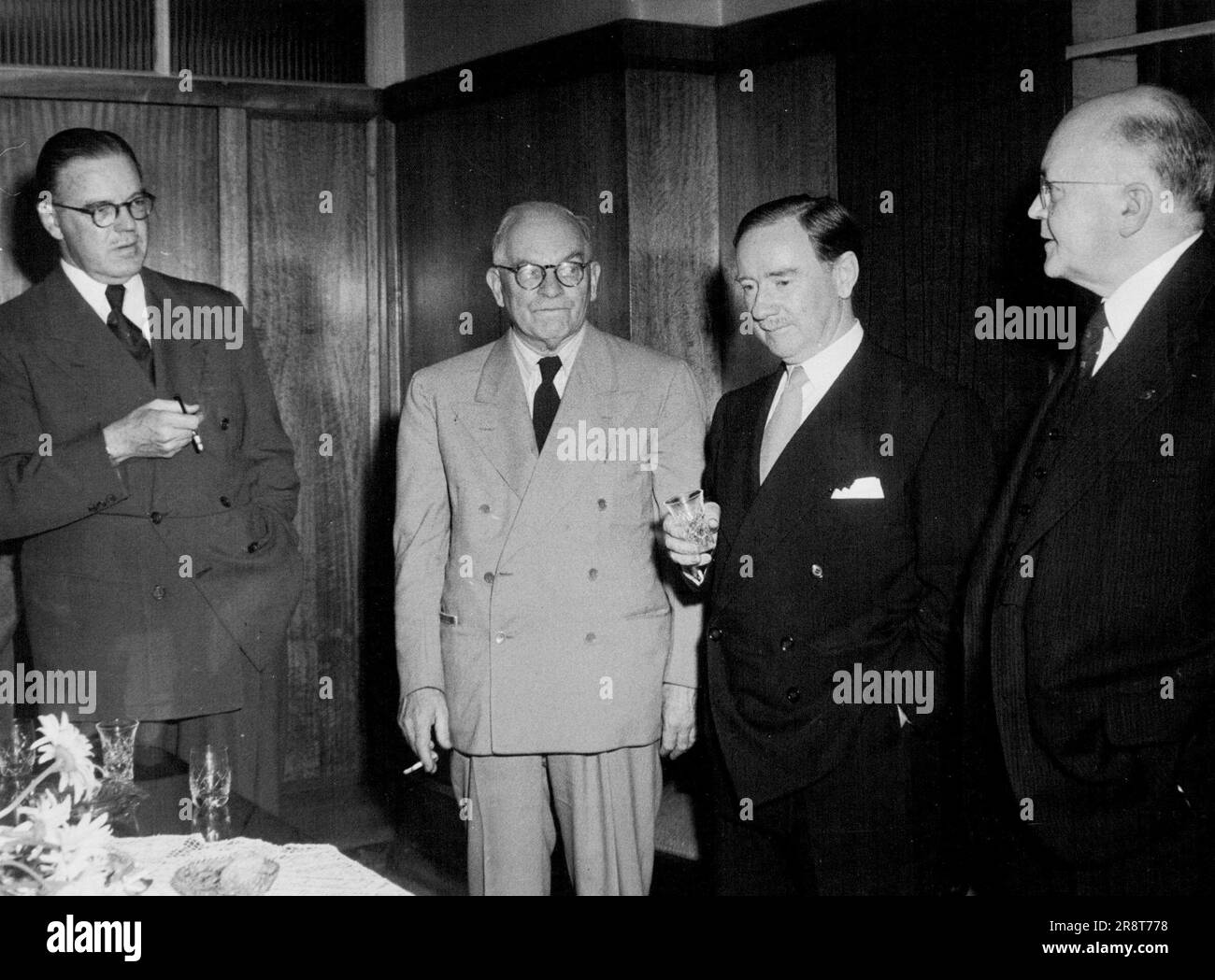 Mr. Alan Williamson, British film pioneer who has just retired as personal representative in Australia of J. Arthur Rank leaves for England shortly. At a gathering of prominent business executives in the Macquarie Board Room this week, the Hon. P.C. Spender, Minister for External Affairs proposed the toast. Shown above (from left) Mr. R.E. Denison, Mng. Dir. of Station 2GB and the Macquarie Broadcasting Service, Mr. Frank Tait, Mng. Dir. of J.C. Williamson Theatres Ltd., Mr. P.C. Spender and Mr. Alan Williamson. January 17, 1951. Stock Photo