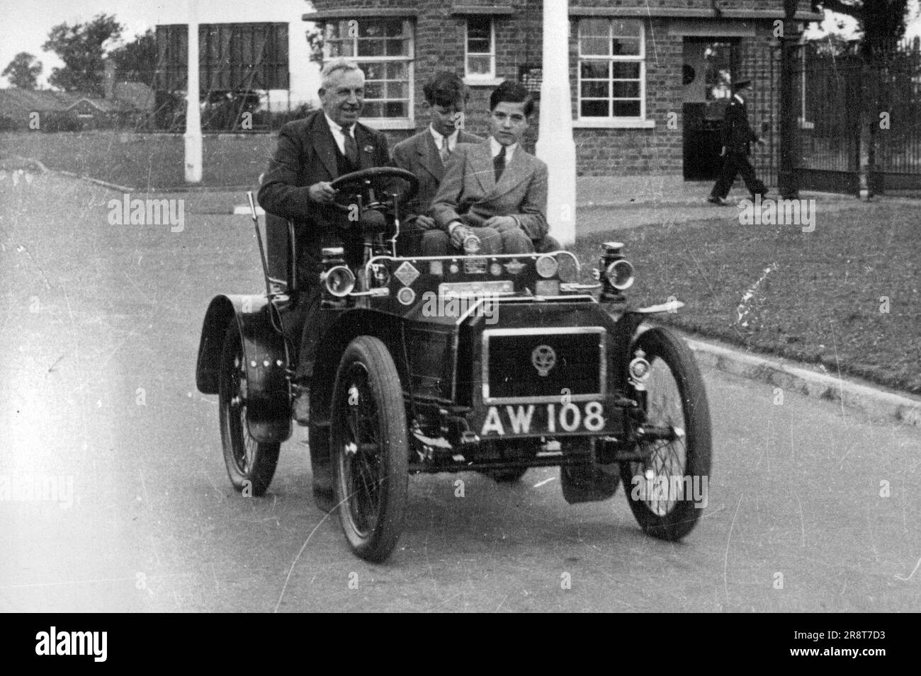 Prince Edward Rides in a Veteran - Prince Edward (centre) with Count Soerring enjoy a ride in a 1903 Humber car, driven by Mr. Sam Wright, Keeper of the Museum. Prince Edward, Duke of Kent with his young friend Count Hans Veit Zu Soerring, were interested visitors to the Motor Museum at Coventry, England, leading centre of the British motor industry. August 14, 1949. (Photo by Sport & General Press Agency, Limited). Stock Photo