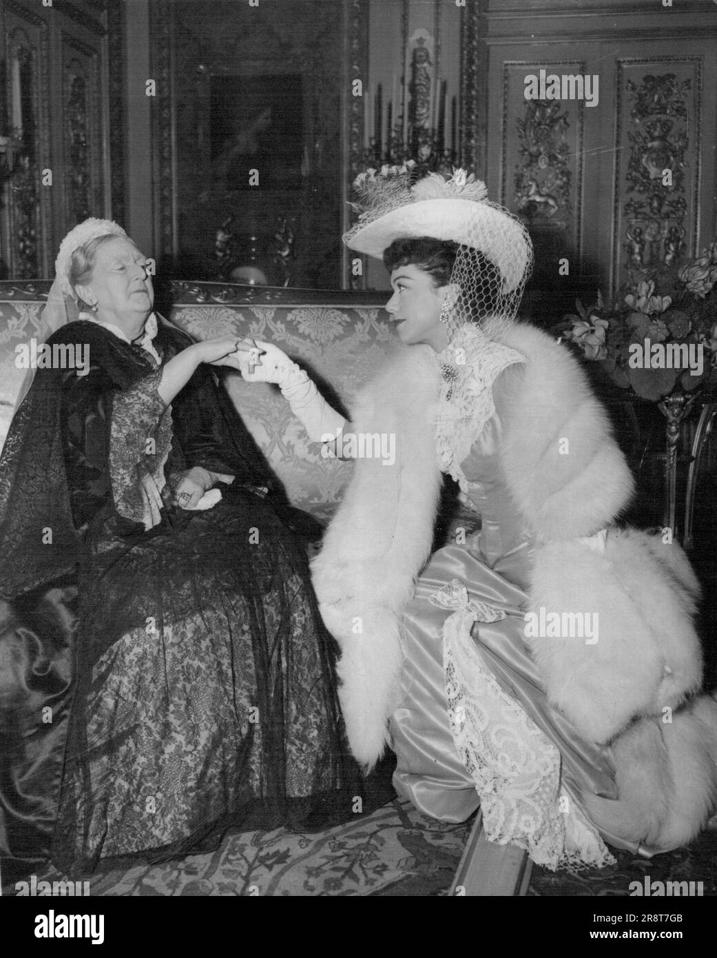 'Queen Victoria Receives Melba' Queen Victoria, played by Dame Sybil Thorndike, receives Dame Nellie Melba, the world famous soprano, played and sung by Patrice Munsel, in the Red Drawing Room at Windsor Castle. This scene from the British colour film 'Melba' was made at the Nettlefold Studios, Walton-on-Thames, Surrey. For the scene, a replica of the red drawing room was built in the studios from details given by Librarian at Windsor Castle. Dame Sybil Thorndike is the sixth actress to play the part of the historic 'old queen'- the others have been Pamela Stanely, Anna Neagle, Irene Dunn… Stock Photo