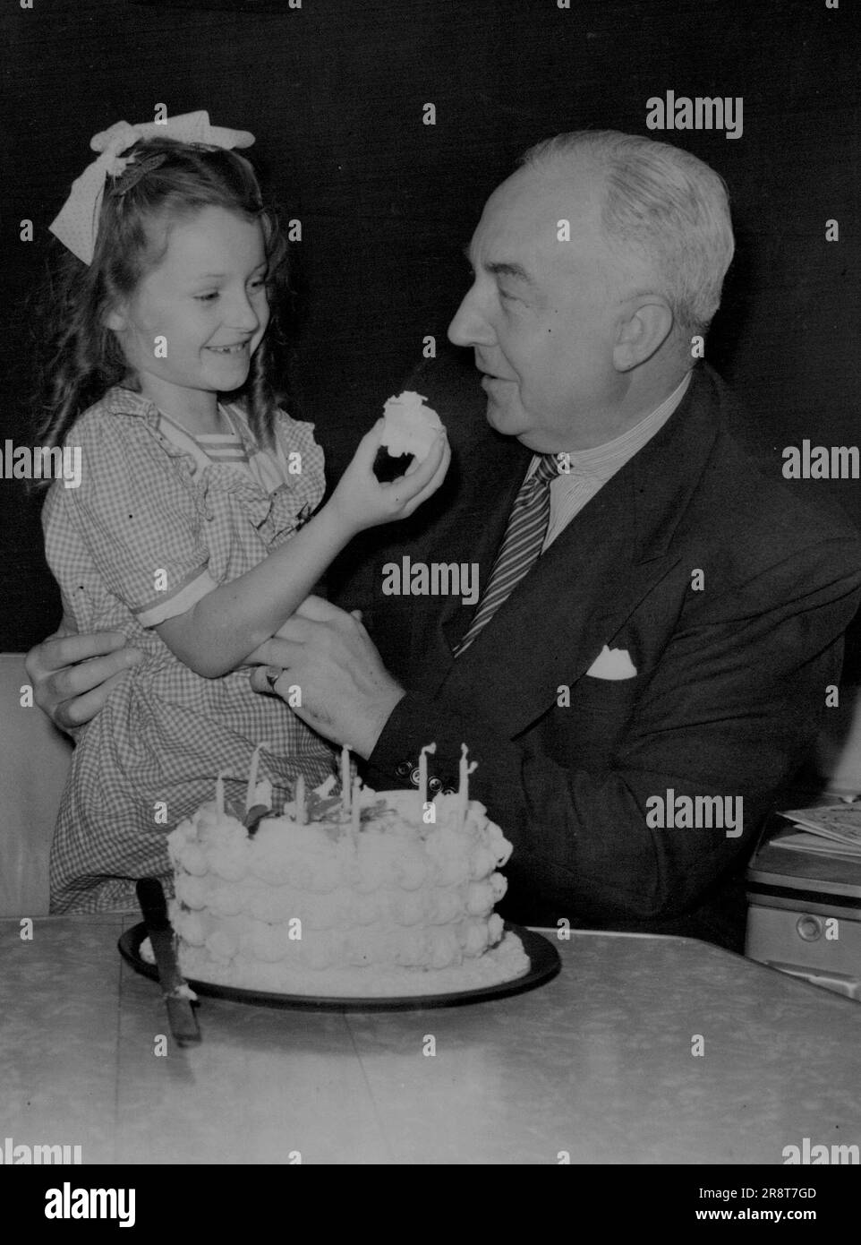 Tempting! Susan Celebrates Birthday On New Flight. Susan Gillette tempts Sir Miles Thomas, B.O.A.C. Chairman, with a piece of her eighth birthday cake, which she cut in the plane before leaving-on her 8,000 miles flight to Hong Kong. Sir Miles was there to inaugurate the first service. Inaugurating British Overseas Airways Corporation's first landplane service to Hong Kong, the Argonaut, new 36-ton, 40-seater, pressurised, air-conditioned monoplane left London Airport. Passengers included Mrs. B. Gillette of Bristol, and her four children, going out to Hong Kong to join her husband. One o… Stock Photo