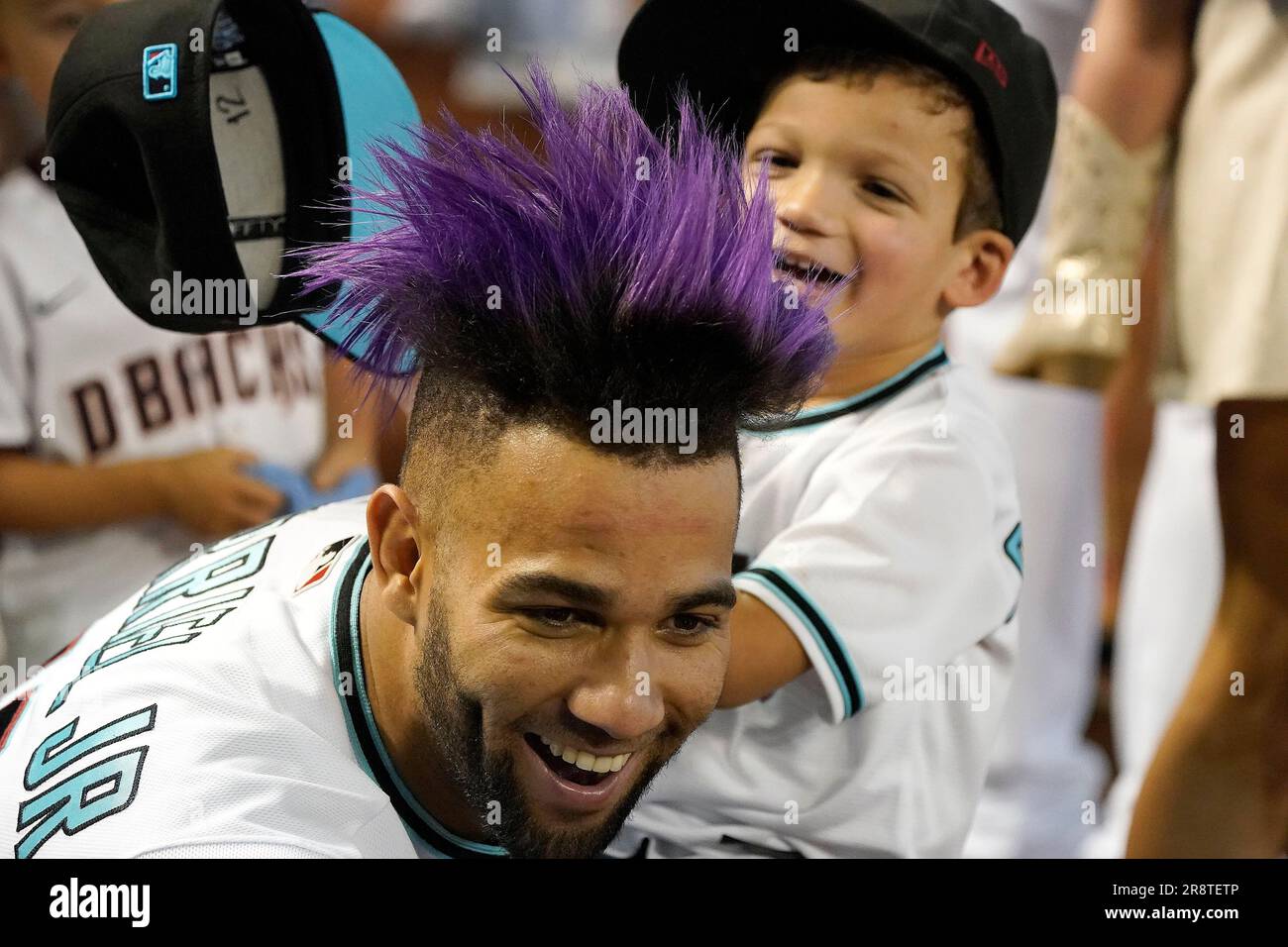 Arizona Diamondbacks' third baseman Lourdes Gurriel Jr. laughs as one of  his sons steals his hat before their game with the Cleveland Guardians,  Sunday, June 18, 2023, in Phoenix. (AP Photo/Darryl Webb