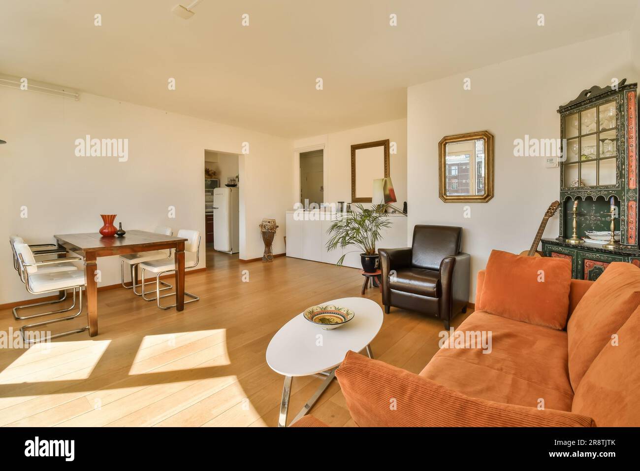 a living room with an orange couch and coffee table in the photo is