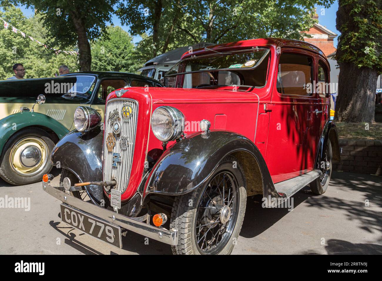 A red 1930's Austin Seven with a starting handle protruding from the radiator grille. Austin Ruby at a classic and vintage car show. Stock Photo