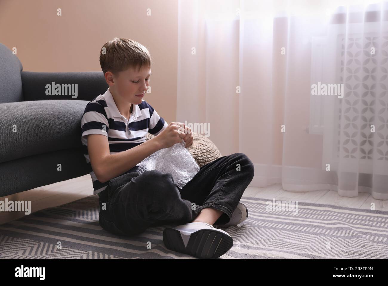 Boy popping bubble wrap at home. Stress relief Stock Photo - Alamy