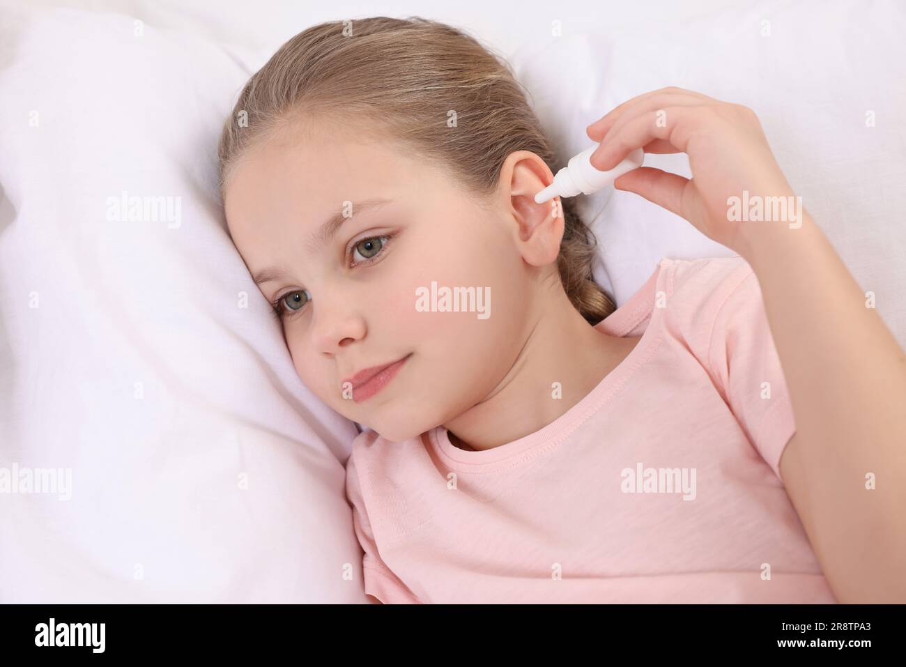 Little girl using ear drops in bed Stock Photo Alamy