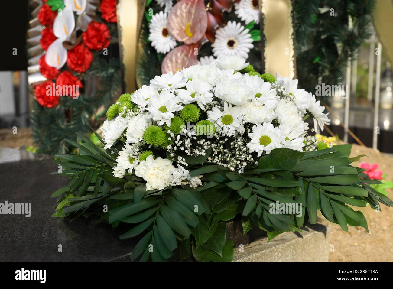 Funeral wreath of flowers on granite tombstone in cemetery Stock Photo ...