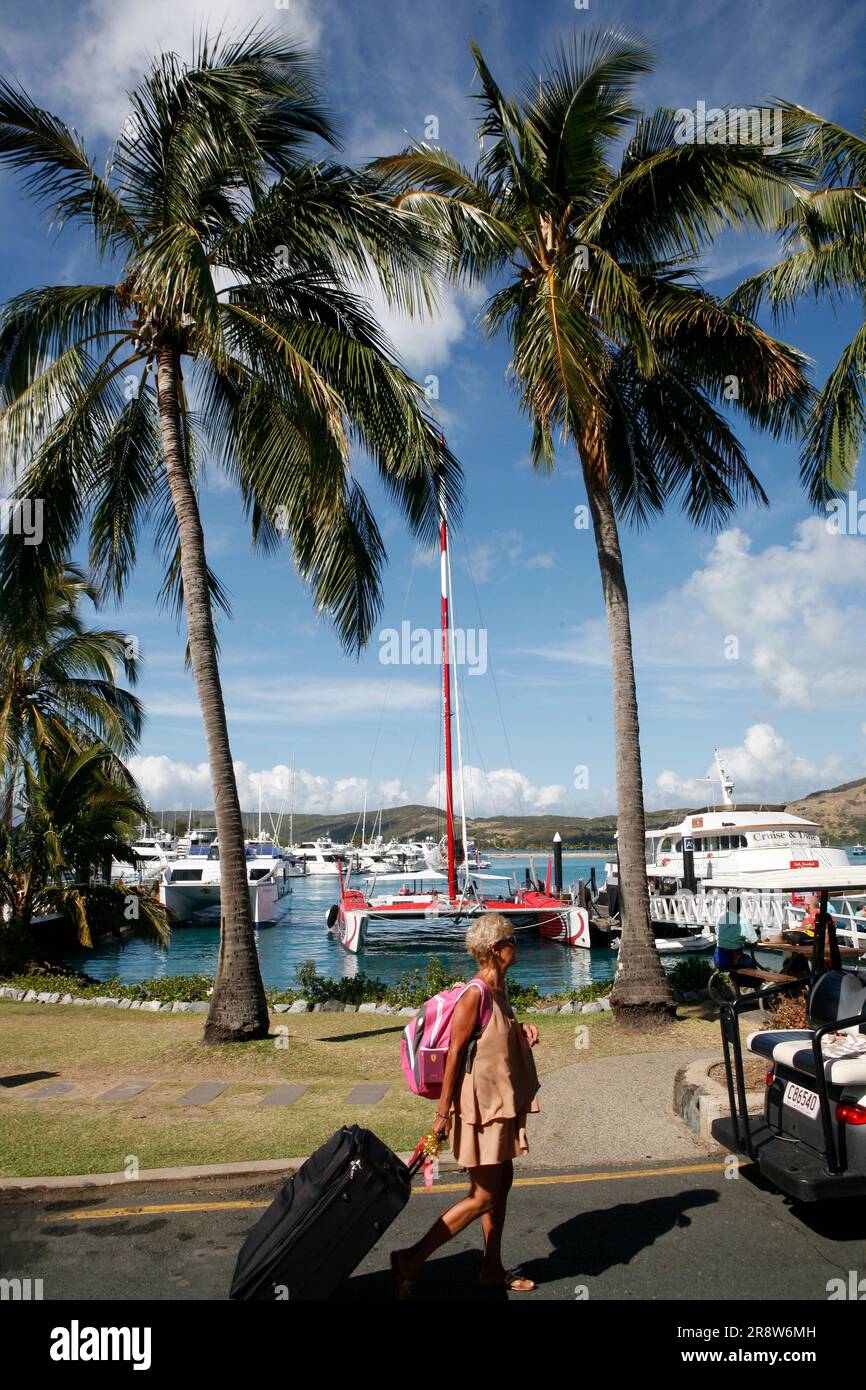 Travelers pulling bags at Whitsunday Islands port in Queensland Stock Photo