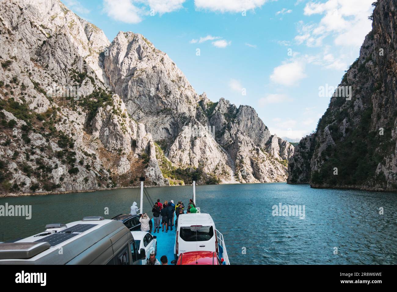 a ferry carries vehicles and passengers through a gorge on Lake Koman, a large reservoir constructed on the Drin River in northern Albania. Stock Photo