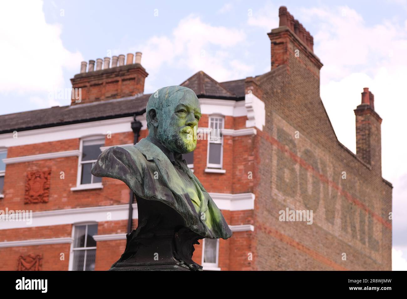 Brixton, UK. A bronze bust of Thomas Tate in Windrush Square is defaced with yellow paint, due to his indirect connection to the slave trade. Stock Photo
